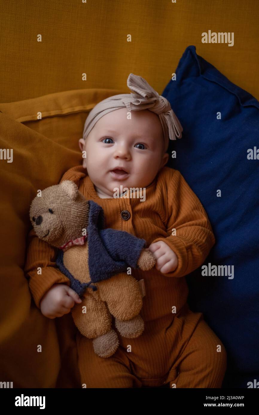 baby girl sitting with teddy bear and smiles Stock Photo - Alamy