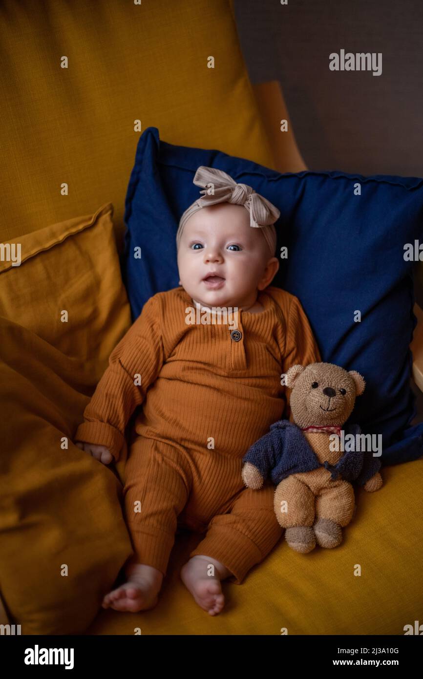 baby girl sitting with teddy bear and smiles Stock Photo - Alamy