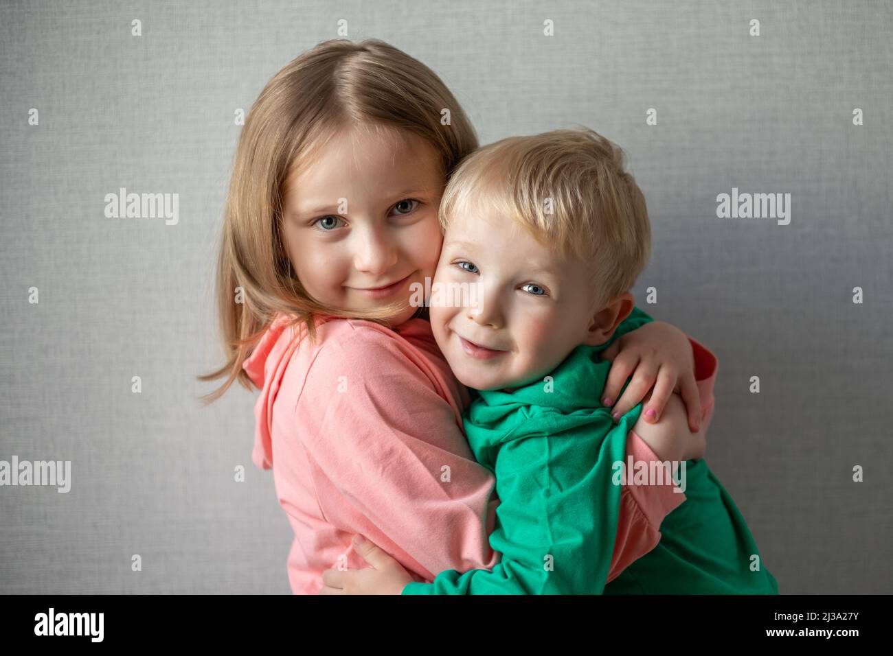 close-up portrait of two children happy and smiling. Blonde brother and sister hugging, sibling relationship concept. funny kids. Boy and girl hugging Stock Photo