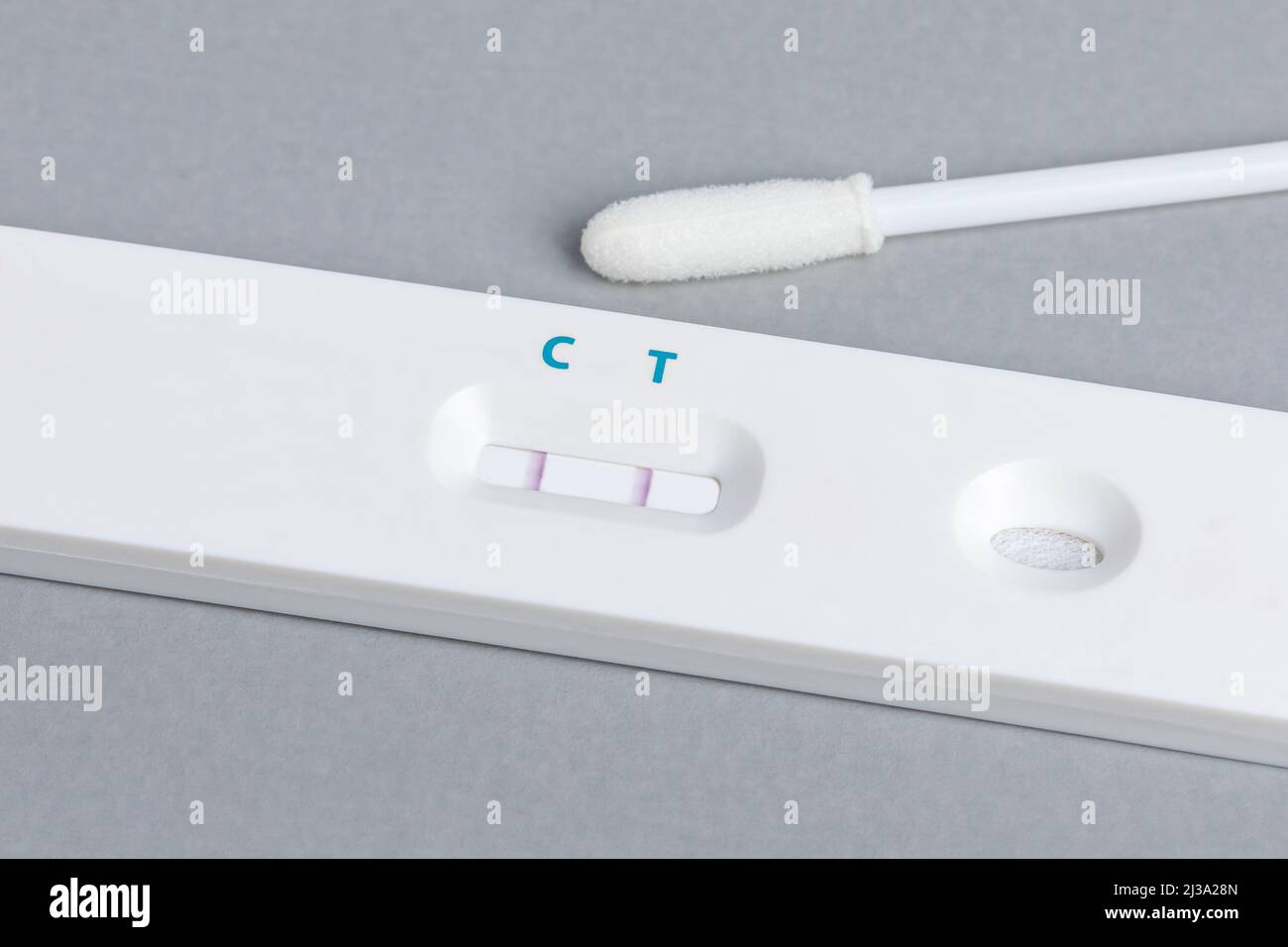 Covid-19 rapid test kit with positive result. Coronavirus home testing, pandemic and healthcare concept. Stock Photo