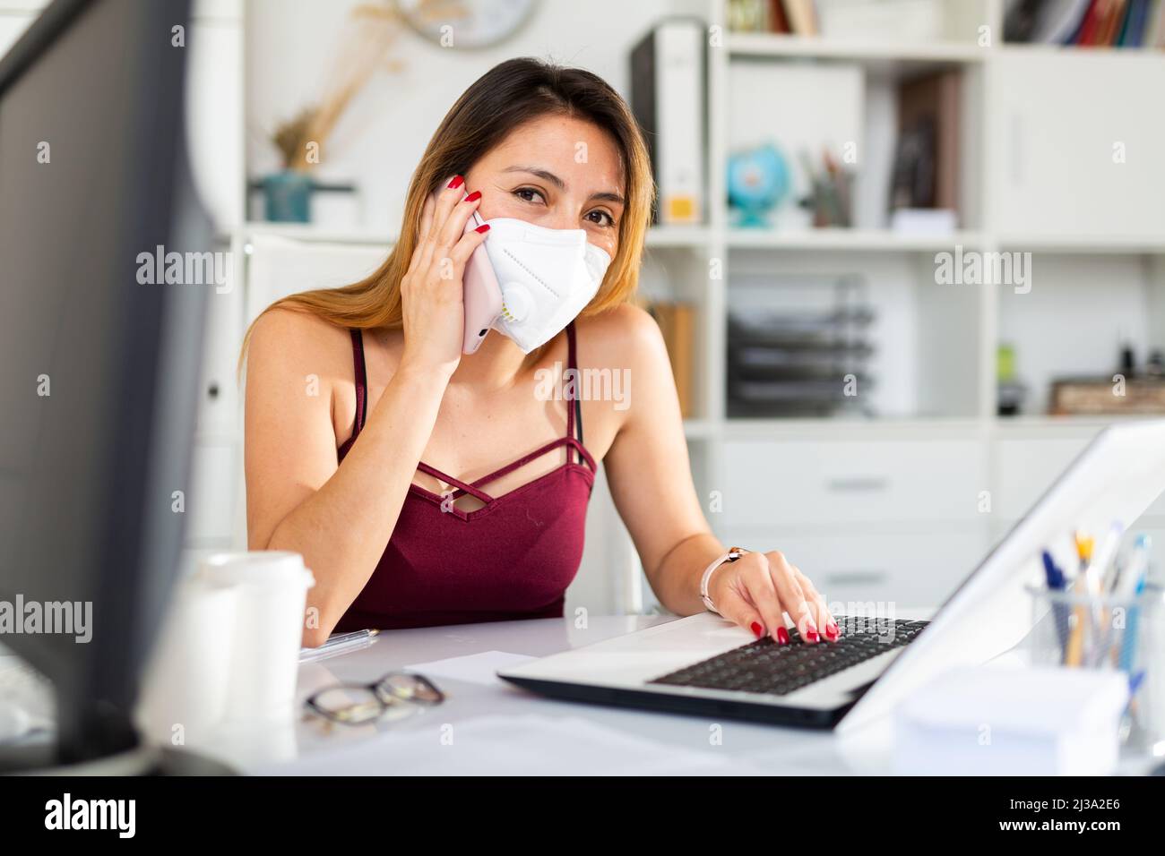 Businesswoman in face mask using phone Stock Photo