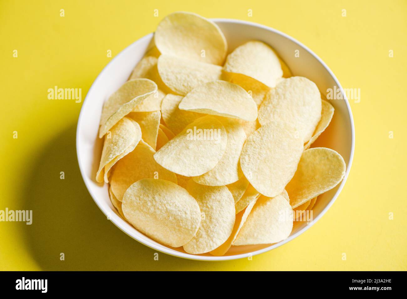 Potato chips snack on bowl and yellow background, Crispy potato Stock