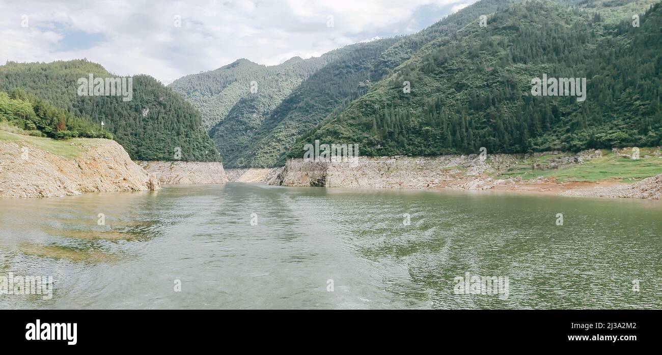 A Panoramic view of a river flowing through mountains and dense forest ...