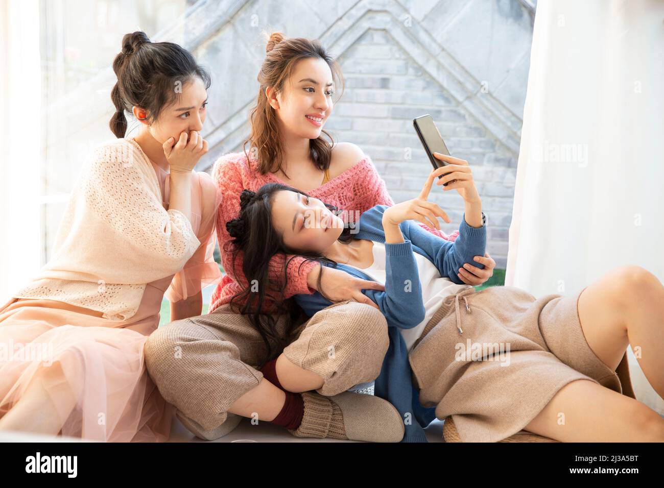 Chinese beautiful young fashionable ladies leisure party, browsing the entertainment consultation in the mobile phone - stock photo Stock Photo