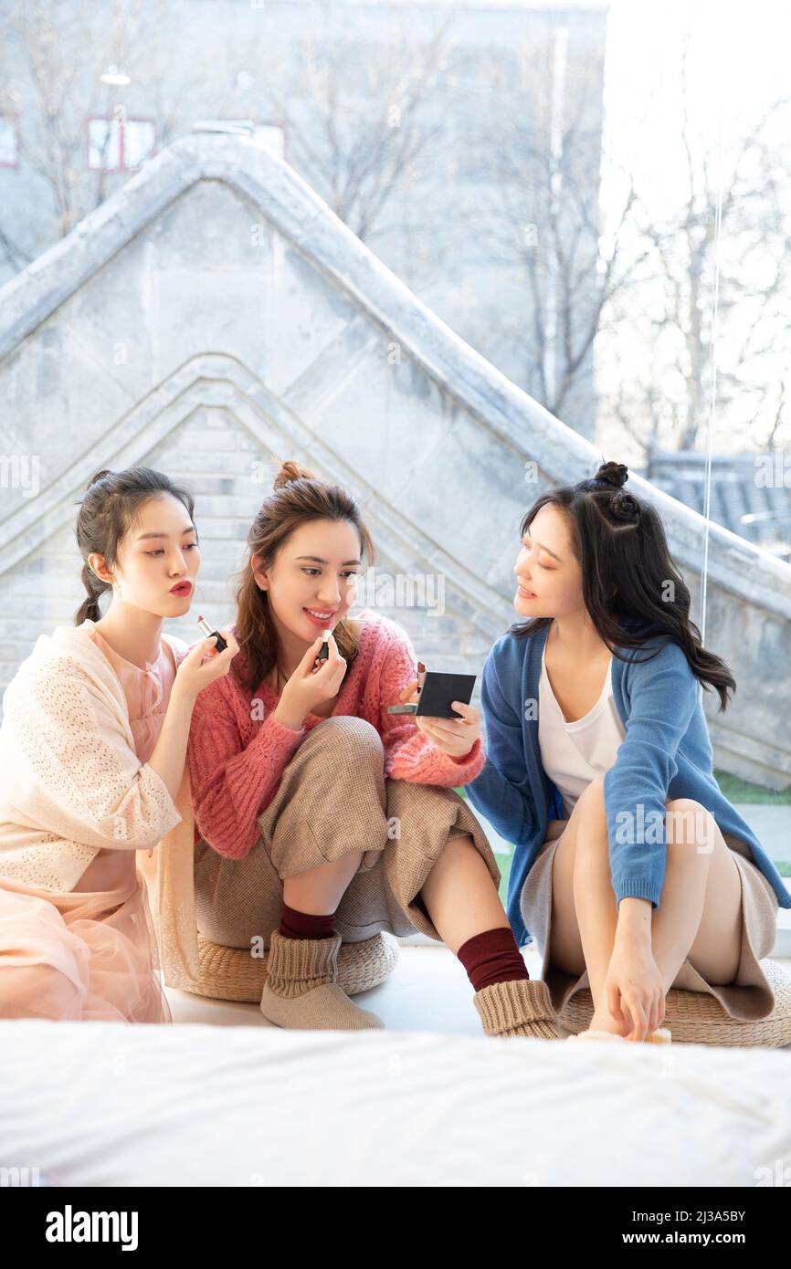 Beautiful young fashionable Chinese ladies try lipstick in their spare time - stock photo Stock Photo