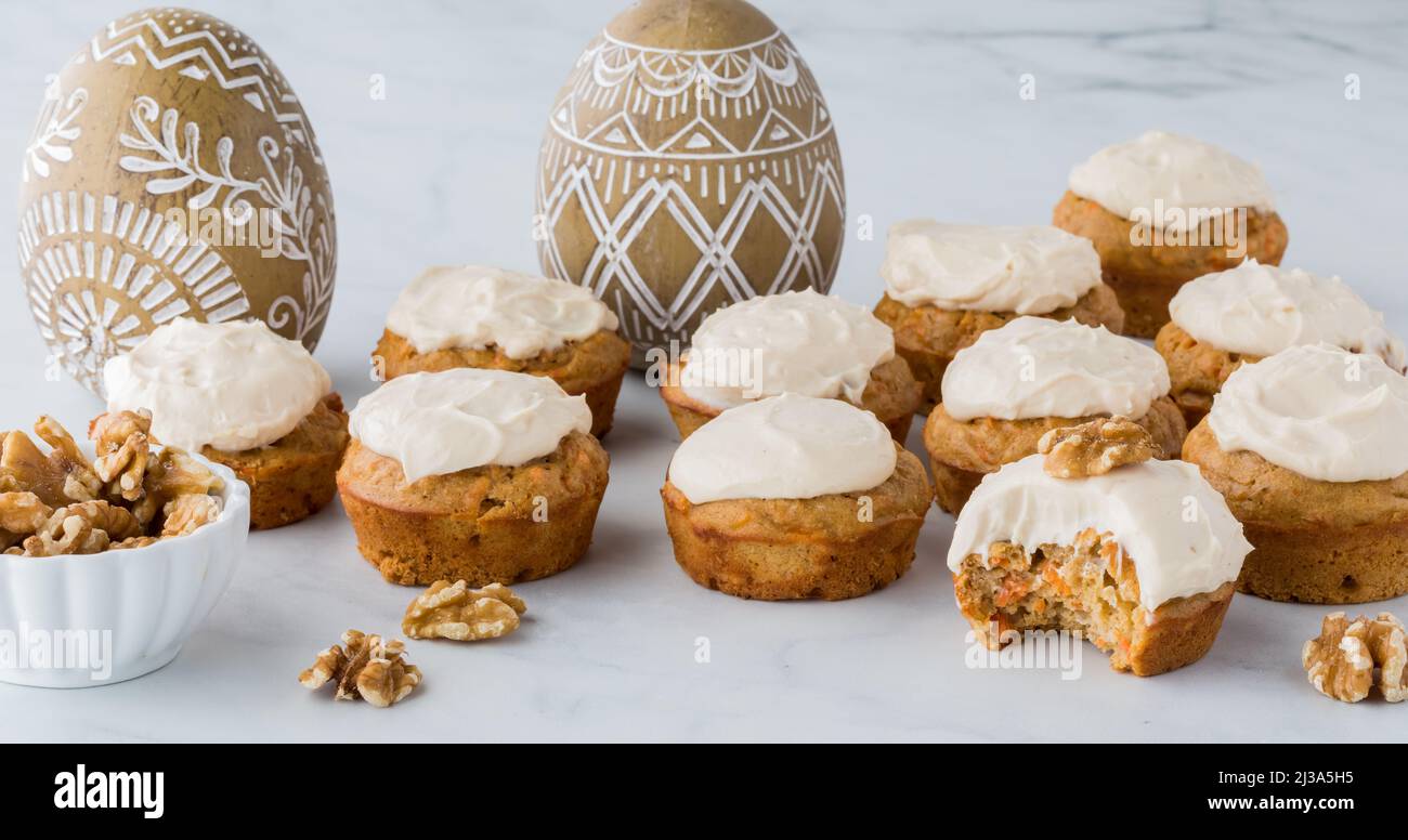 Several homemade carrot cake muffins with a bite out of the one in front. Stock Photo