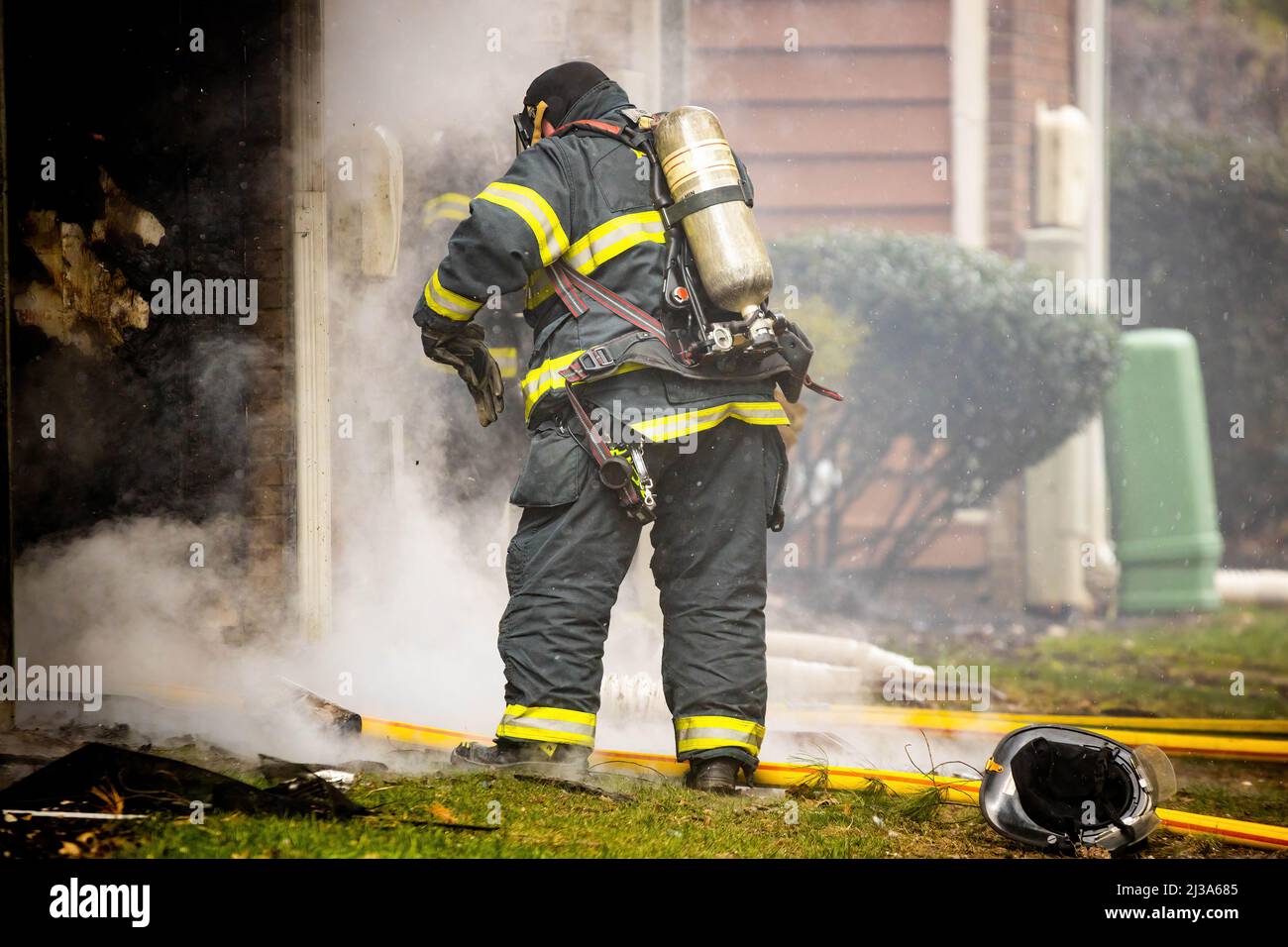Firefighter wearing protective gear and oxygen mask at the scene Stock
