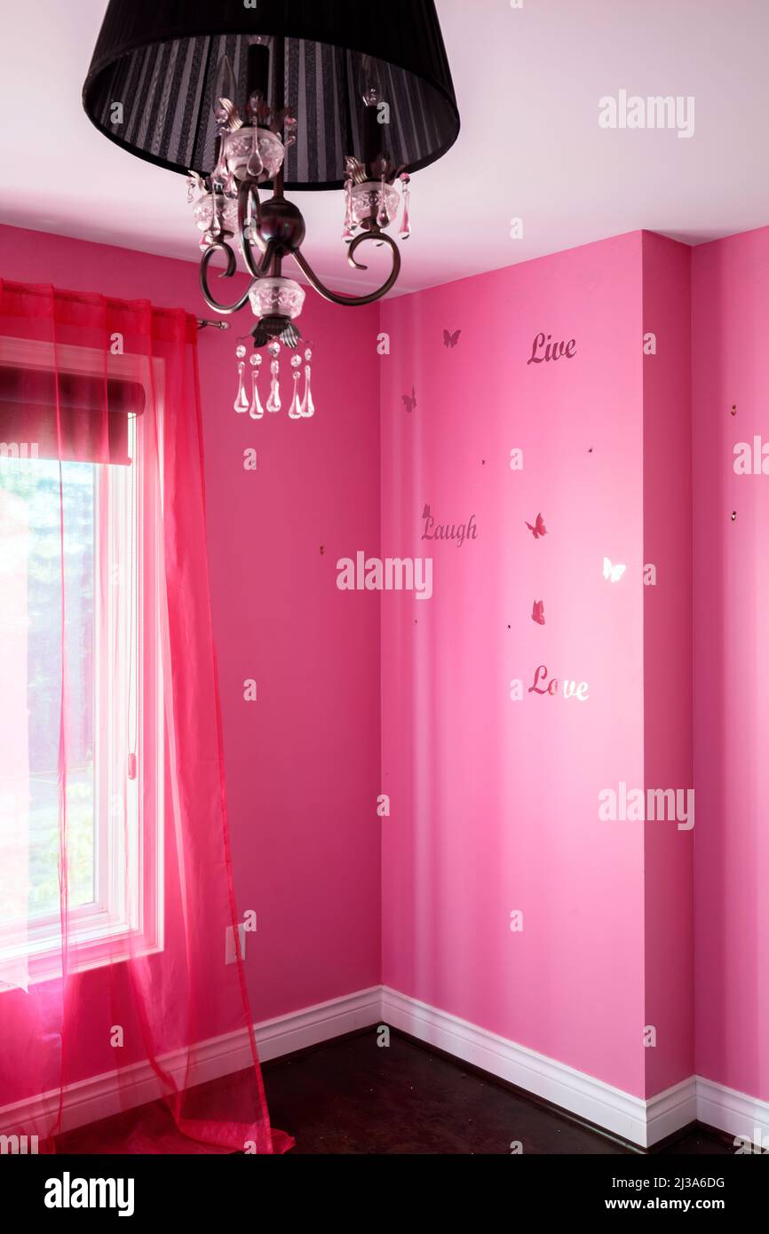 A bright pink bedroom with a black light fixture.  This house has since been demolished. Stock Photo