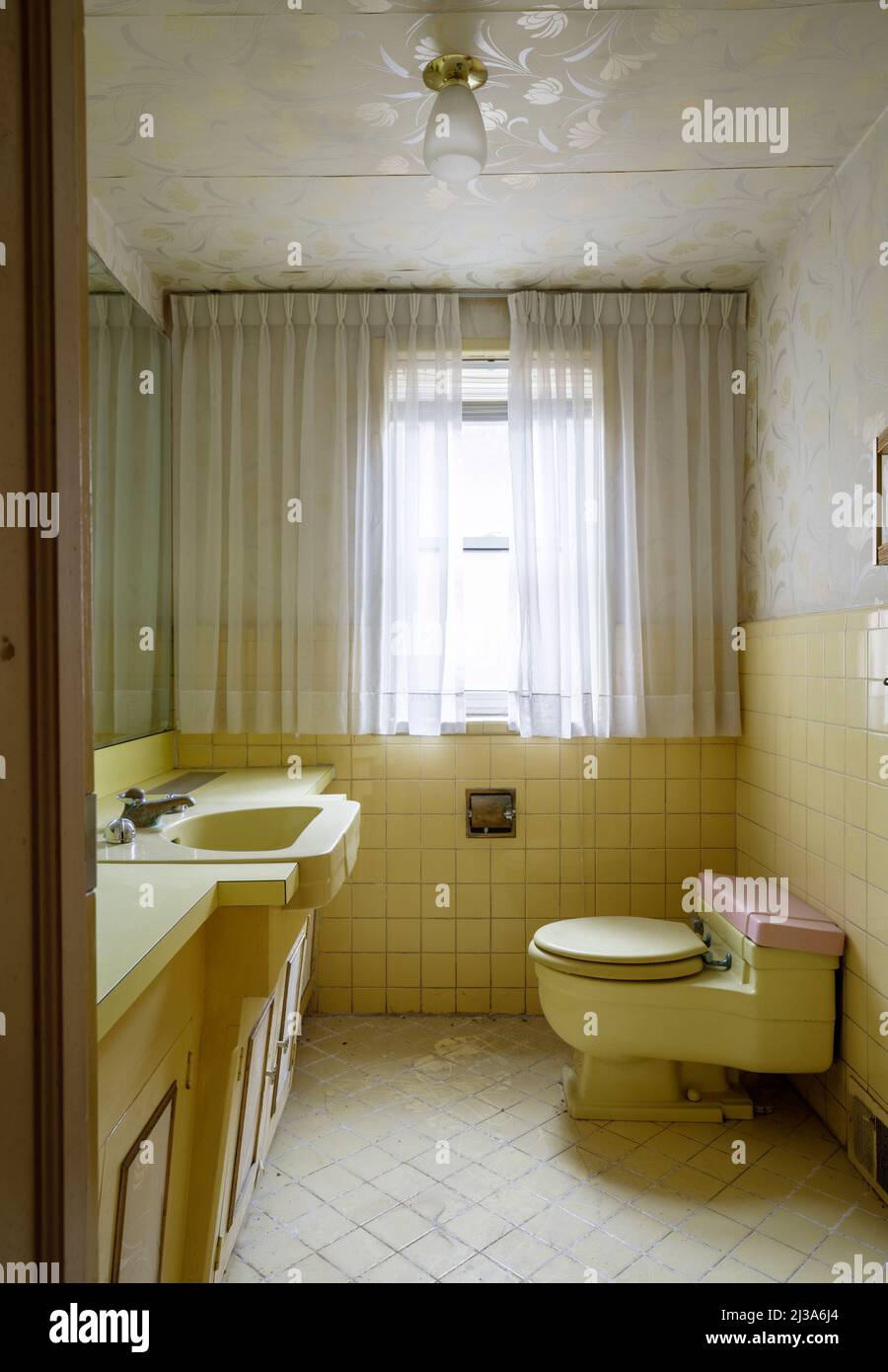 A retro bathroom from the 1960s or 1970s with a yellow theme. This house has since been demolished. Stock Photo