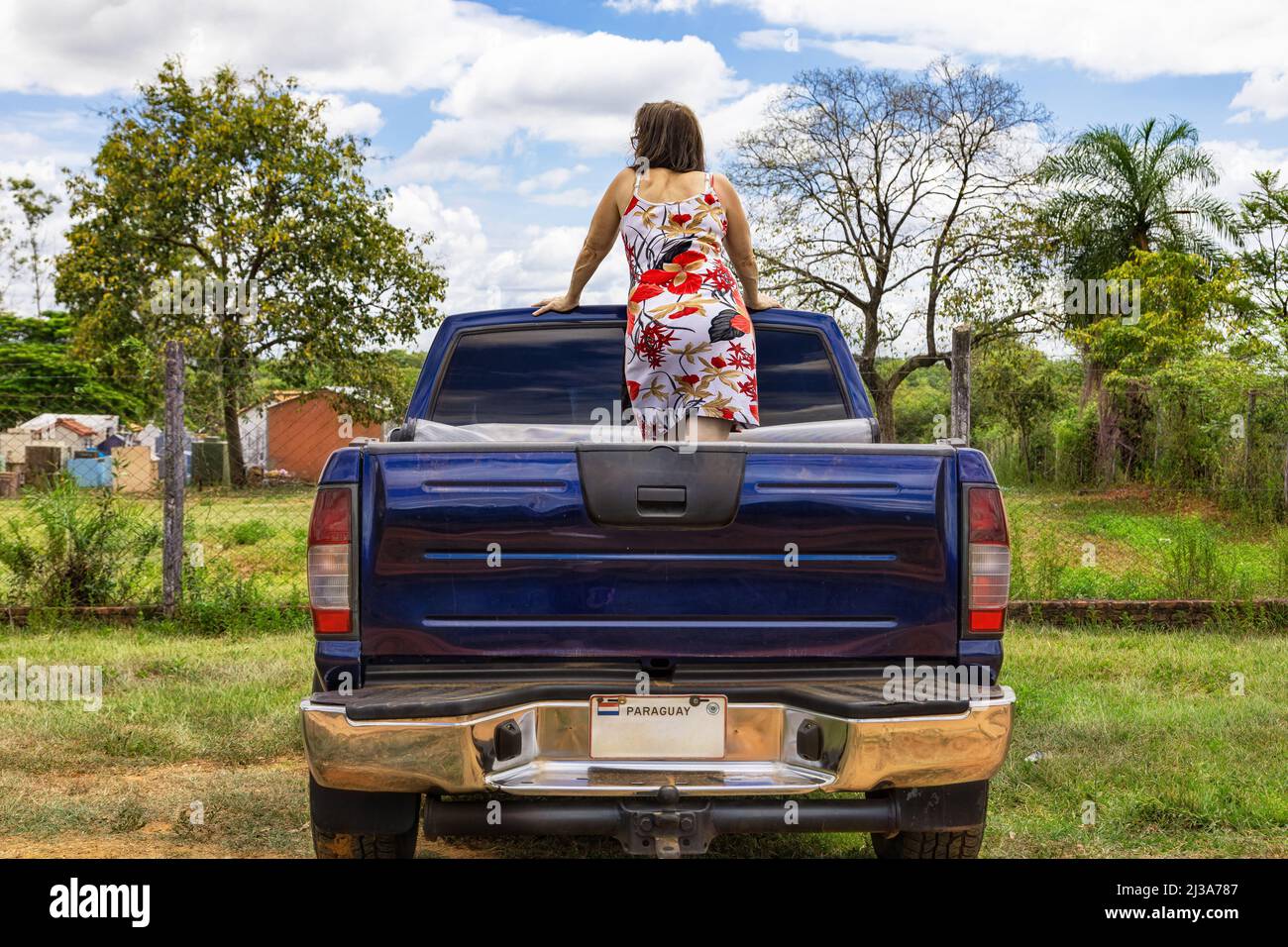A woman stands on the back of a pick-up truck in Paraguay. Stock Photo