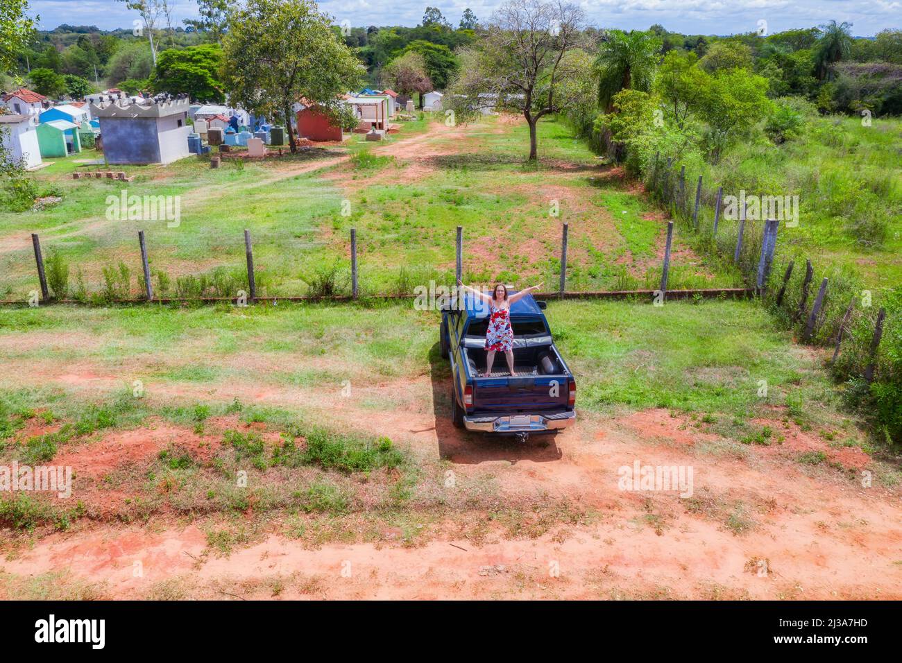 Aerial view of a woman standing on the back of a pick-up truck in Paraguay. Stock Photo