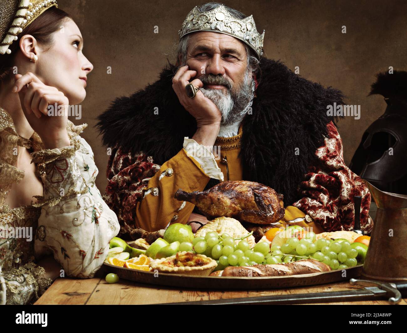 Royal life can be tedious.... A bored queen sitting alongside her husband at a banquet. Stock Photo