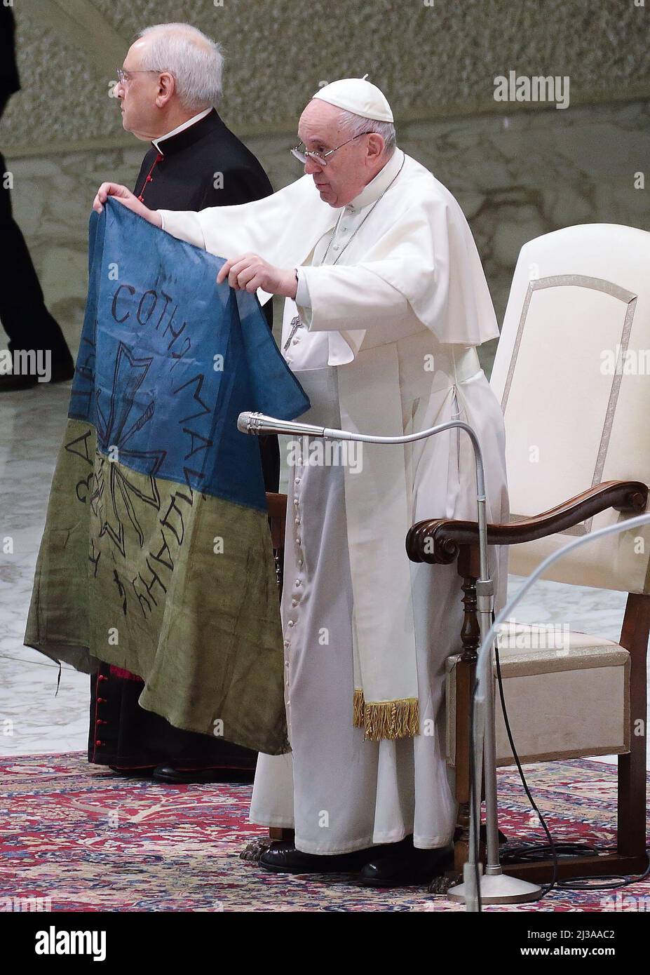 Vatican City State, Holy See. 6th Apr, 2022. The words of POPE FRANCIS during his wednesday general Audience while holding a tattered Ukrainian flag: 'The recent news about the war in Ukraine, instead of bringing relief and hope, instead testifies to new atrocities, such as the Bucha massacre: increasingly horrendous cruelties, also committed against civilians, women and defenseless children. They are victims whose innocent blood screams up to heaven and implores: put an end to this war! Stop sowing death and destruction! Let us pray togheter for this. And yesterday, just from Bucha, they bro Stock Photo