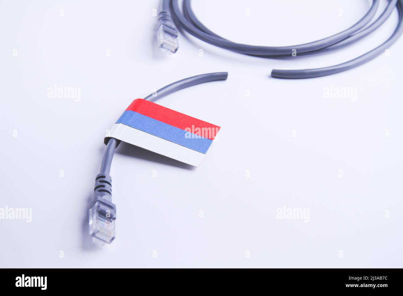 Internet and Russia. Internet cable on the background of the Russian flag. Internet shutdown. Cut cable. Internet access blocking. Stock Photo