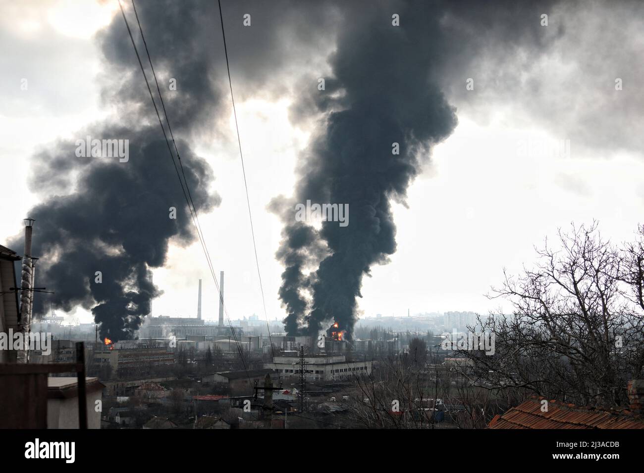 The pillars of smoke rise above the territory of an oil refinery and an