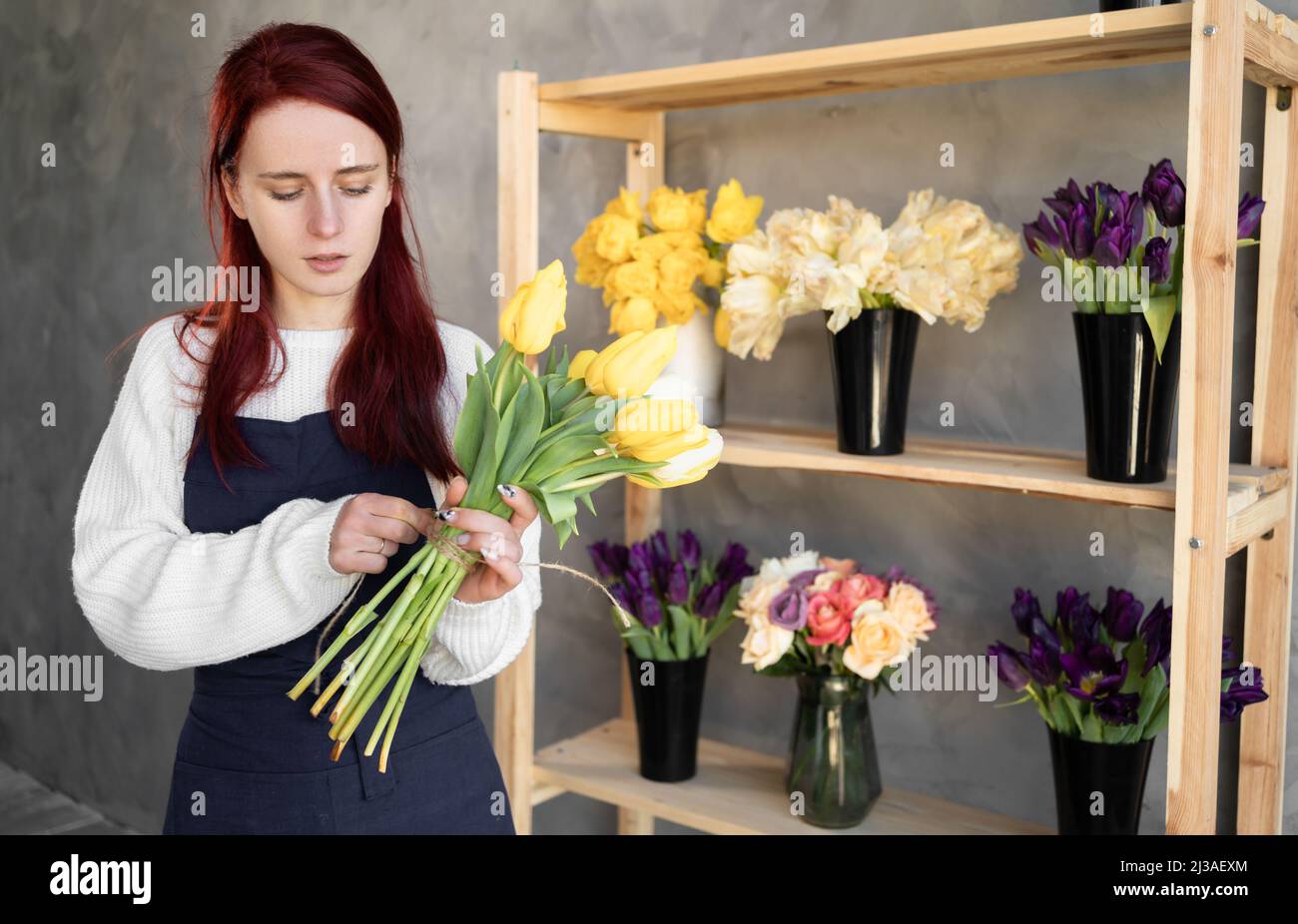 European flower shop concept. A female florist creates a beautiful