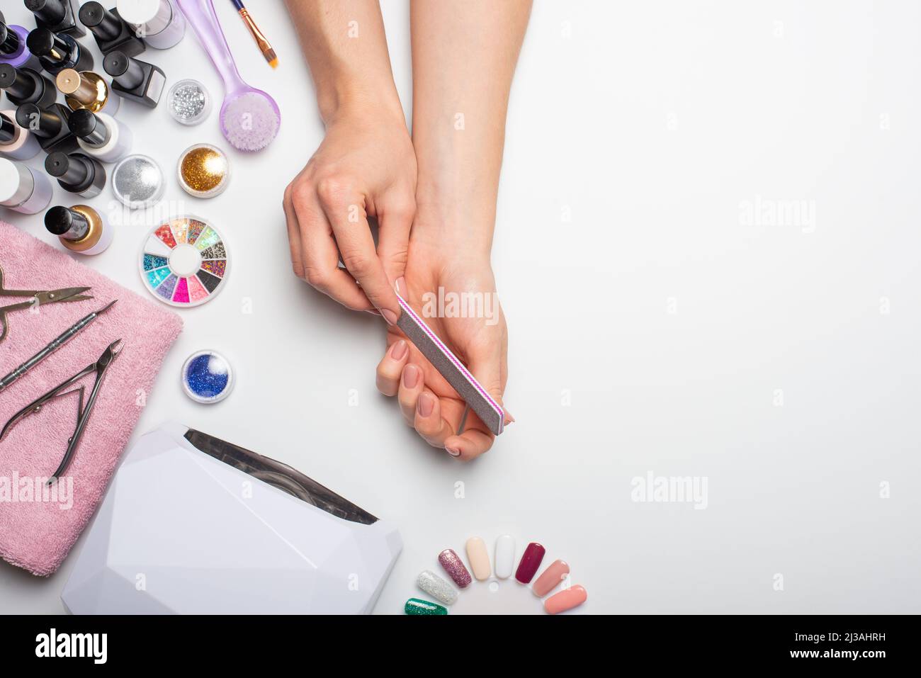 Nail care. beautiful women hands making nails painted with pink gentle nail  polish on a white background. Women's hands near a set of professional man  Stock Photo - Alamy