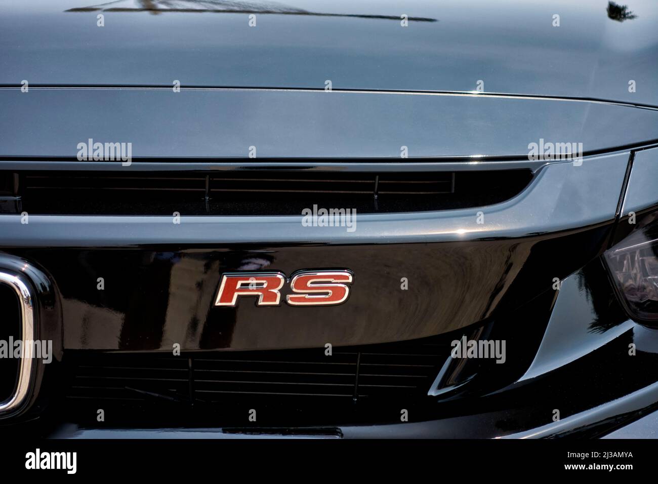 Honda Civic RS car badge designation in red lettering on a black paint