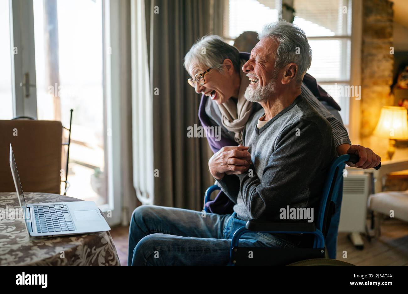 Happy romantic senior couple hugging and enjoying retirement at home Stock Photo