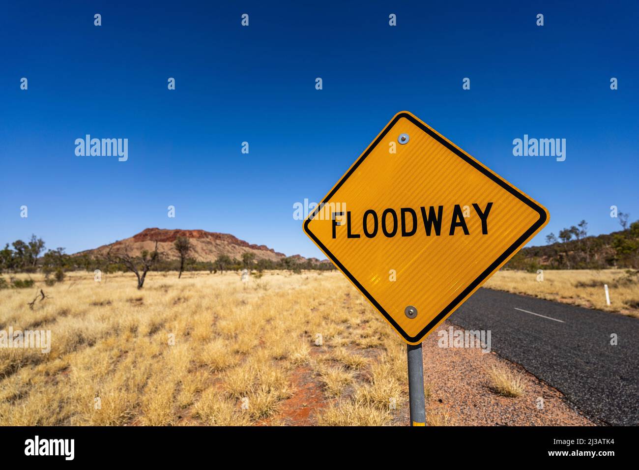 Flood warning sign on outback Australian road Stock Photo