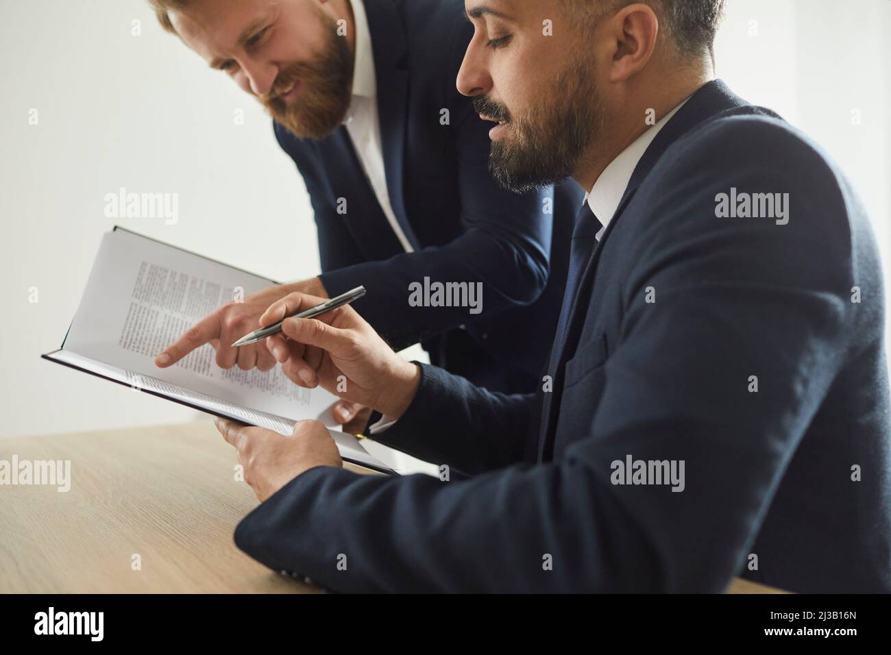 Serious colleagues of lawyers read legal documents together and study information on new legal case. Stock Photo