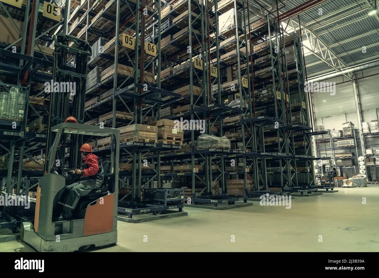 Warehouse of logistic company with forklifts. Large distribution storehouse with high shelves. Stock Photo
