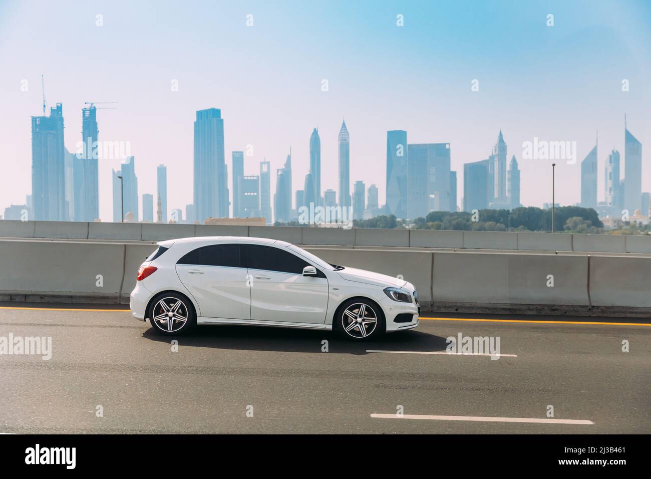 Dubai, UAE, United Arab Emirates - May 28, 2021: White Mercedes-Benz A-Class car fast mooving on street in Dubai. Mercedes-Benz A-Class is subcompact Stock Photo