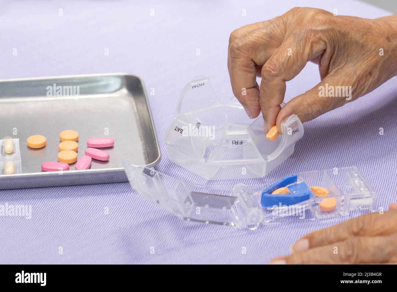 Elderly woman using pill splitter or pill cutter Stock Photo Alamy