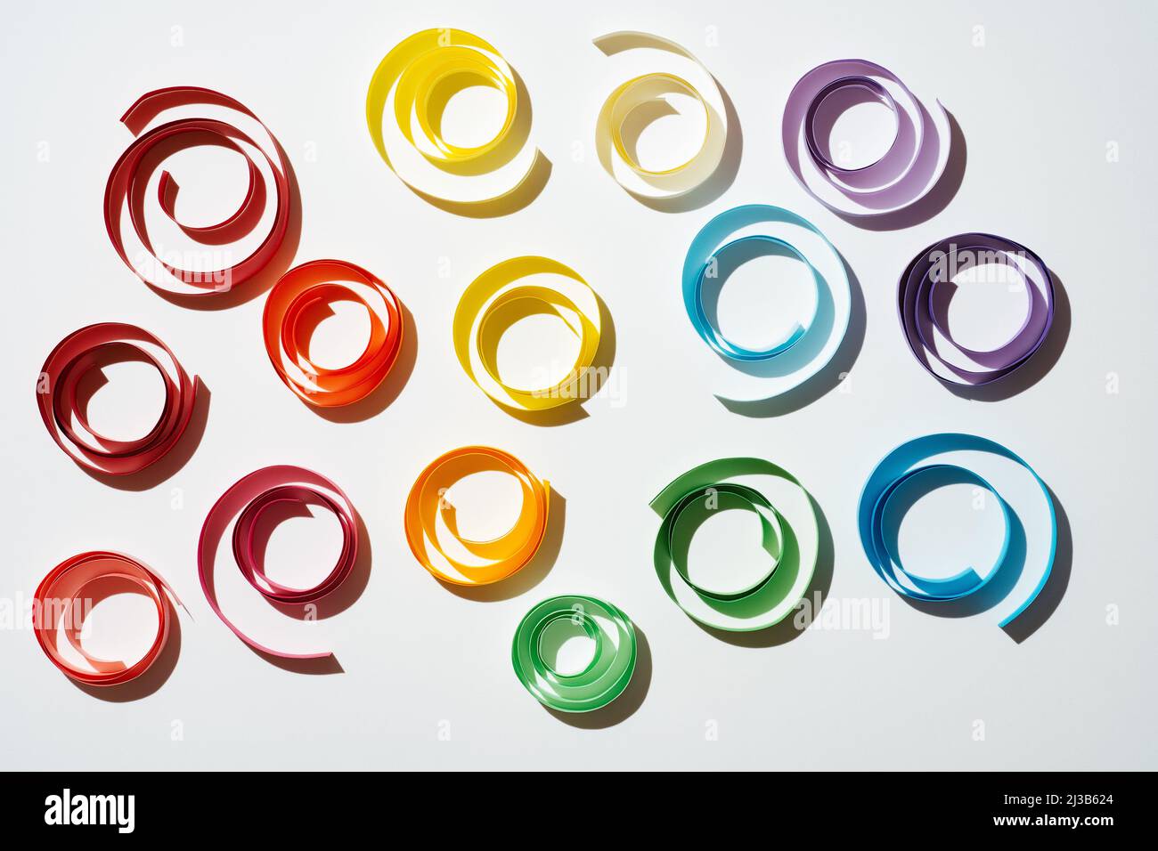 Rainbow colored paper circles on white background. Multicolor spirals pride Stock Photo