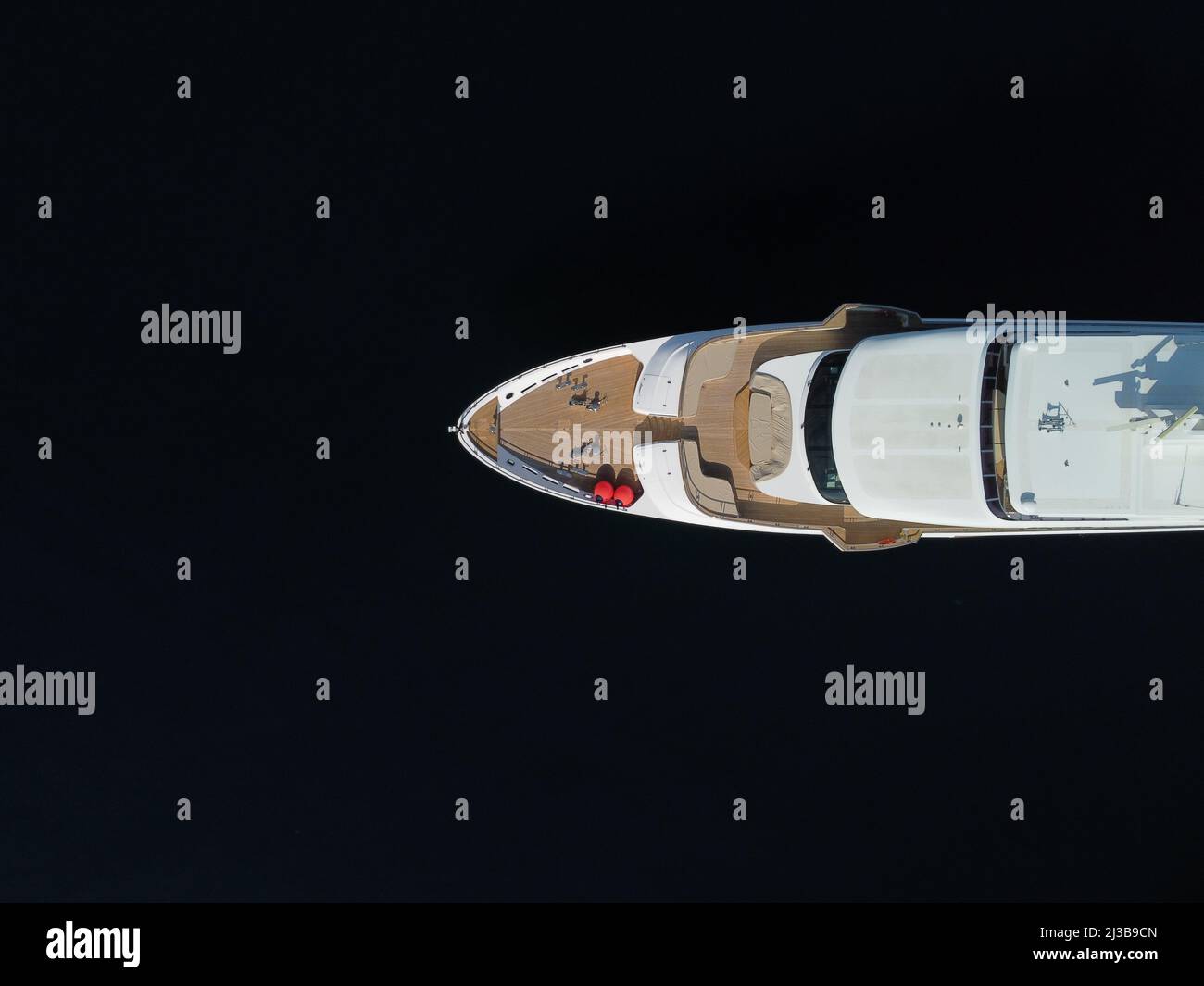 Aerial - Top down view of catching luxury motor boat racing on the water Large luxury yacht floats in the sea port on a background of blue water top Stock Photo