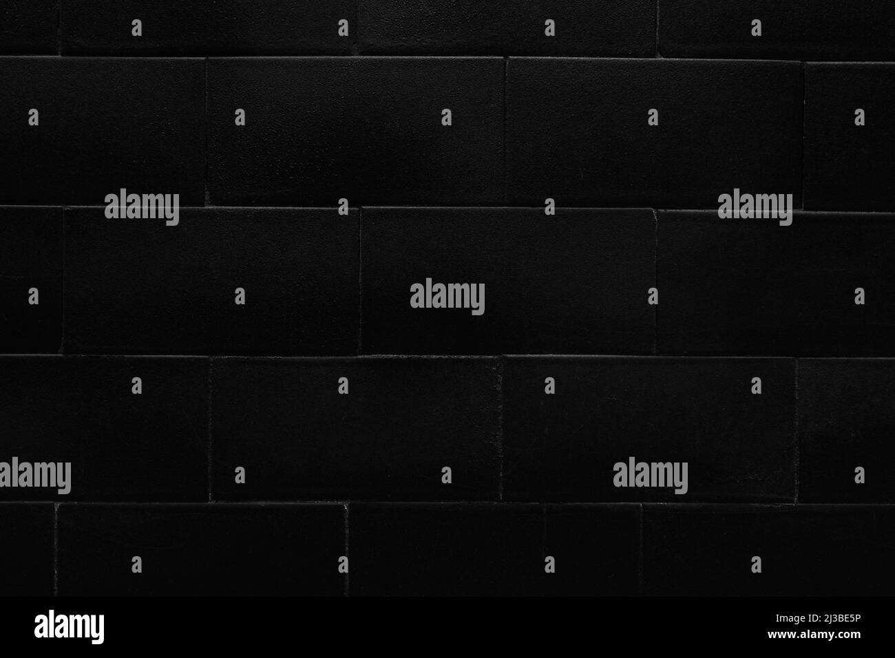 Black tiled wall with brick design. Geometric pattern. Abstract dark background Stock Photo
