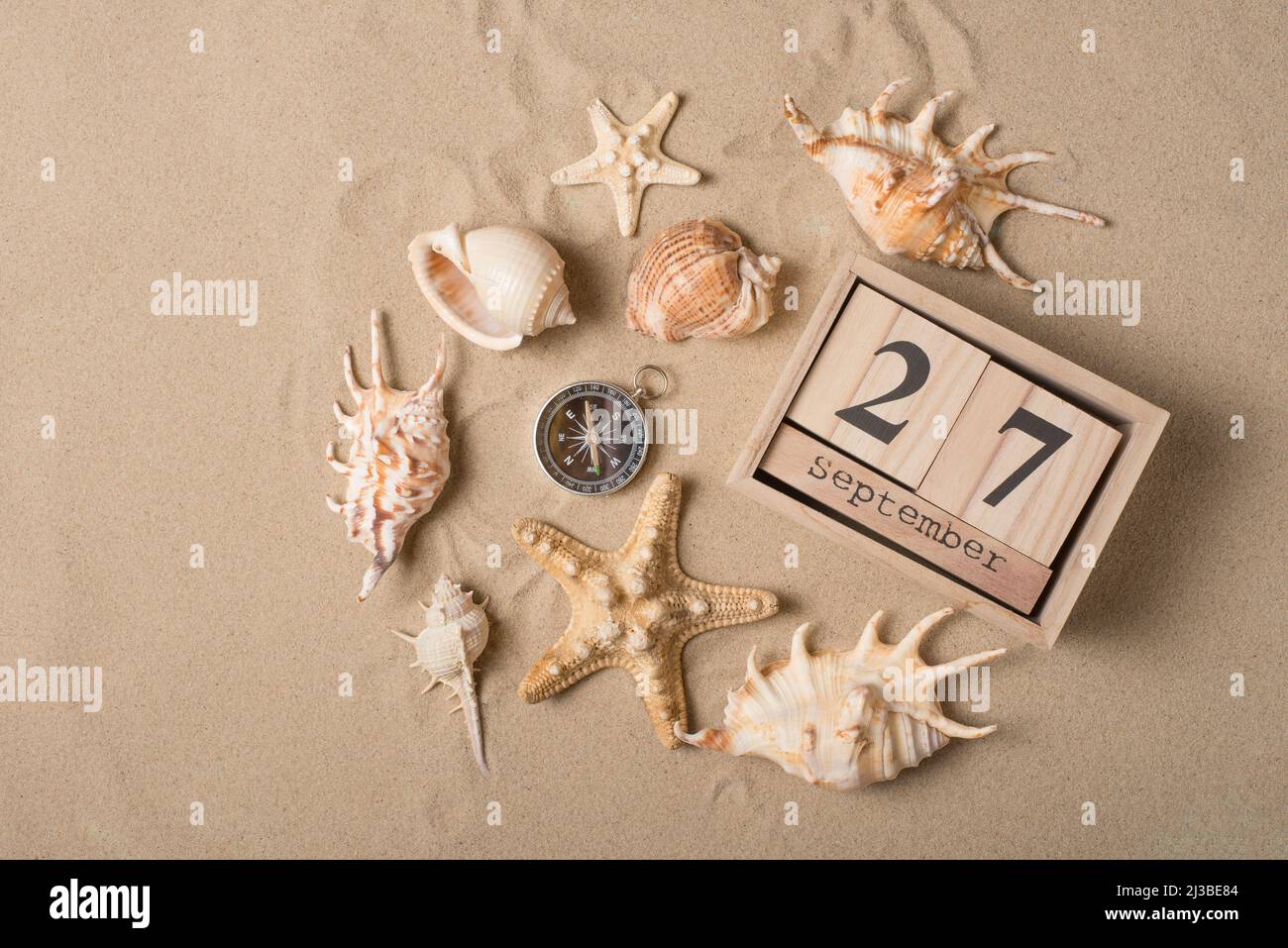 Calendar from September 27 with a compass, sand and seashells ...