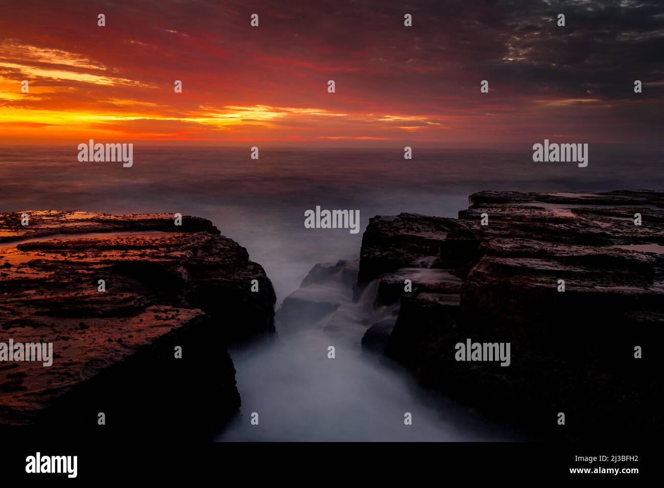 Colourful sunrise at Narrabeen Rocks. Stock Photo