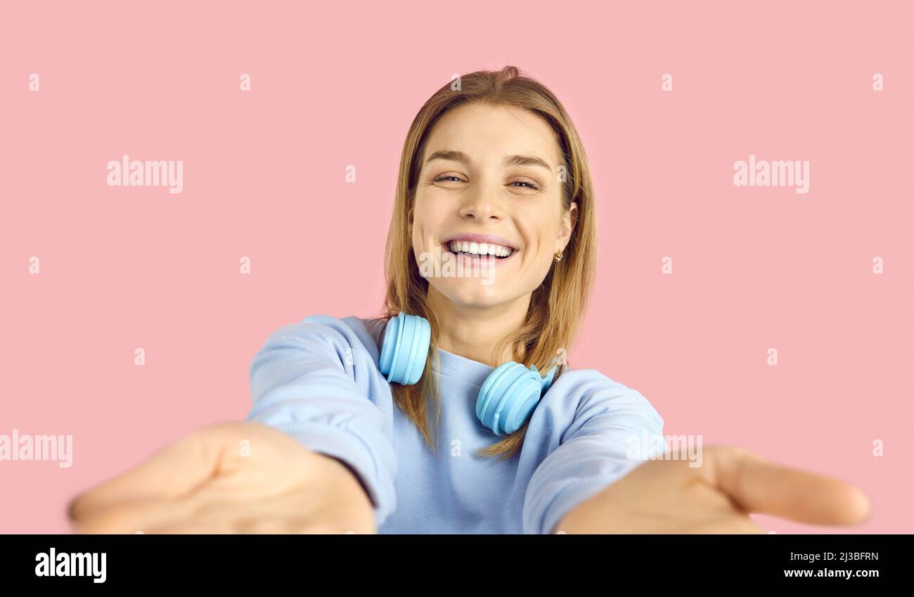 Close up portrait of happy teen girl who reaches out to camera to hold something or hug you. Stock Photo