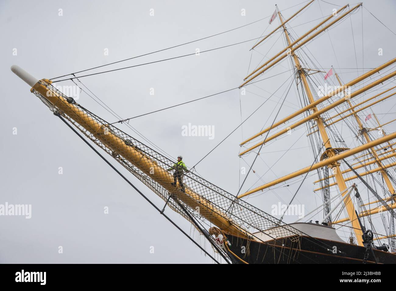 Hamburg, Germany. 07th Apr, 2022. Laura Lühnenschloß, the deputy technical manager of the PEKING, attaches a jib net to the historic four-masted barque 'Peking' at the German Port Museum in Hamburg. During the museum's winter break, the jib net was painstakingly tied by hand from around 4,500 meters of thin rope in the ship's hold. The accessory, made in the traditional way, was attached to numerous sailing ships under the bowsprit and protected the sailors from falling into the water when setting the foresails. Credit: Ulrich Perrey/dpa/Alamy Live News Stock Photo