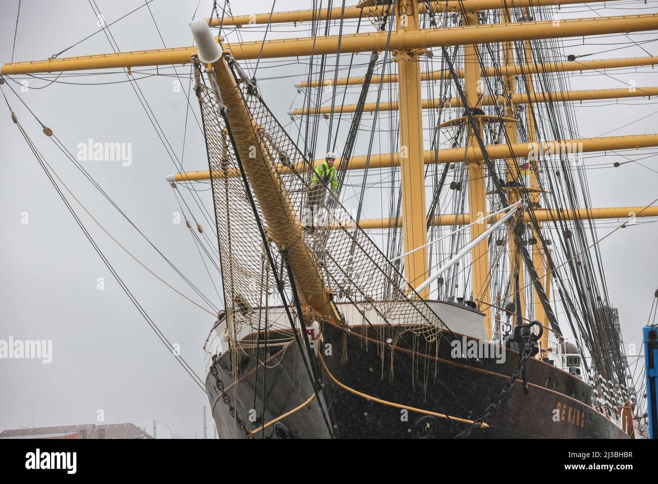 Hamburg, Germany. 07th Apr, 2022. Laura Lühnenschloß, the deputy technical manager of the PEKING, attaches a jib net to the historic four-masted barque 'Peking' at the German Port Museum in Hamburg. During the museum's winter break, the jib net was painstakingly tied by hand from around 4,500 meters of thin rope in the ship's hold. The accessory, made in the traditional way, was attached to numerous sailing ships under the bowsprit and protected the sailors from falling into the water when setting the foresails. Credit: Ulrich Perrey/dpa/Alamy Live News Stock Photo