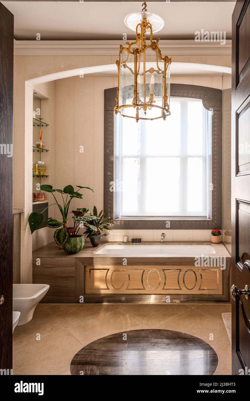 Panelled bath  with privacy screen and gilt lantern in Holland Park, London, UK Stock Photo