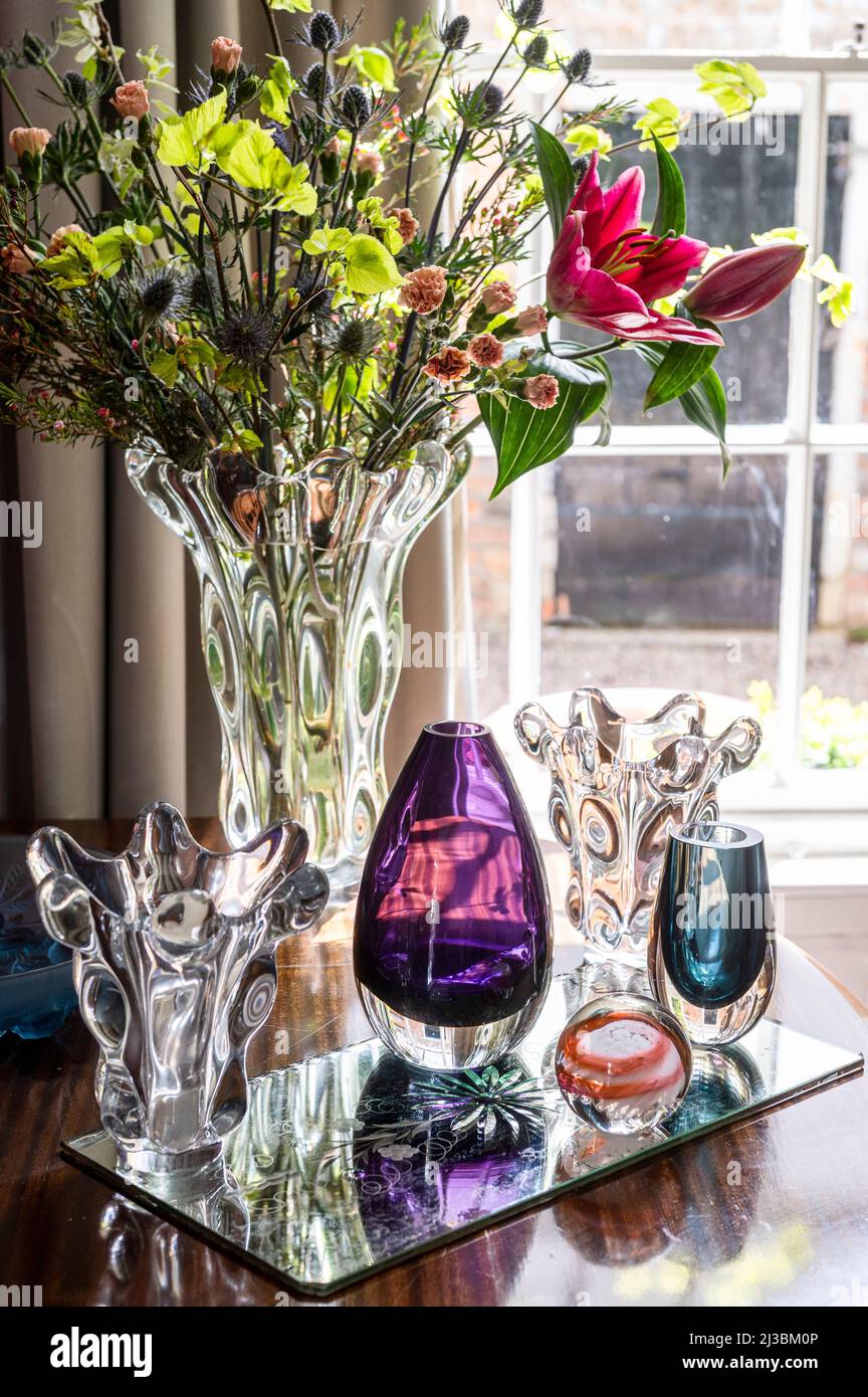 Assorted glassware and lilies in 17th century Suffolk home, UK Stock Photo