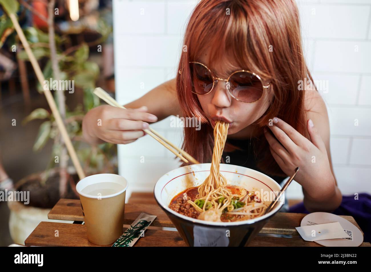 Girl eating noodles Stock Photo Alamy