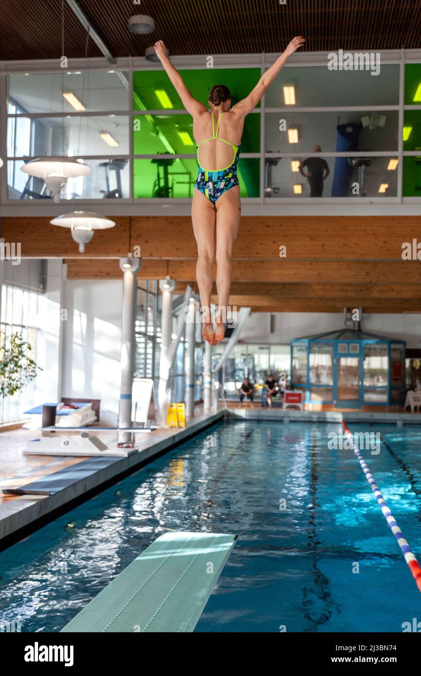 Girl jumping from diving board Stock Photo