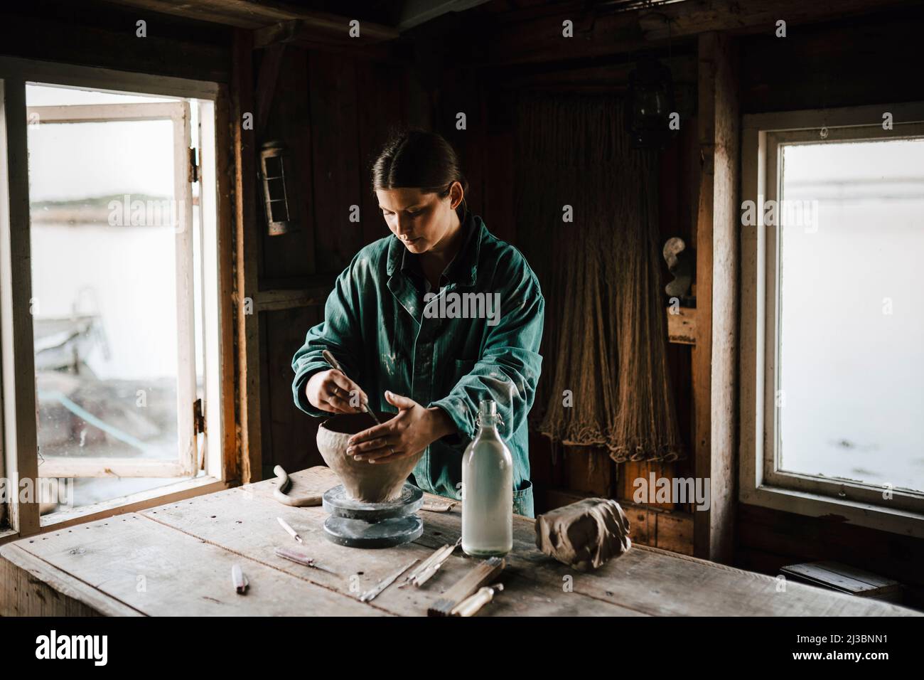 Female potter making vase in workshop Stock Photo