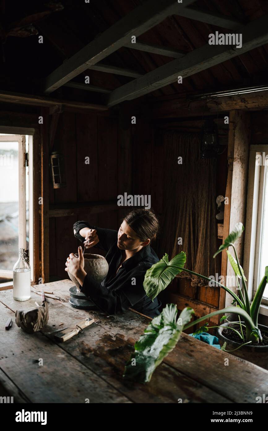 Female potter making vase in workshop Stock Photo