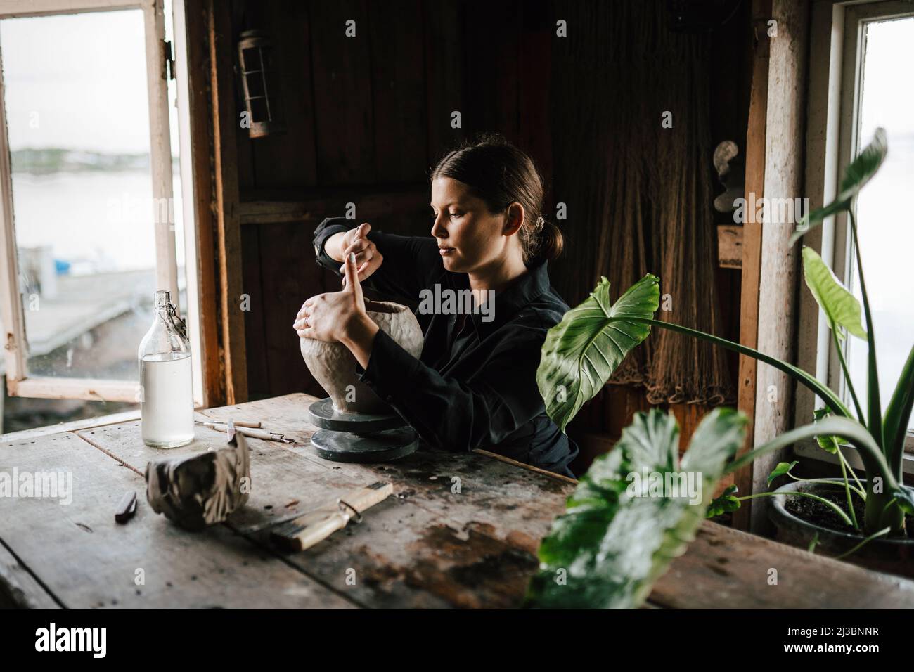 Female potter making vase in workshop Stock Photo