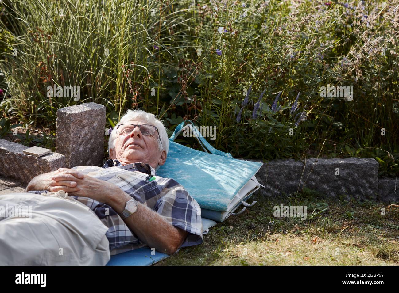 Senior man relaxing on lawn Stock Photo