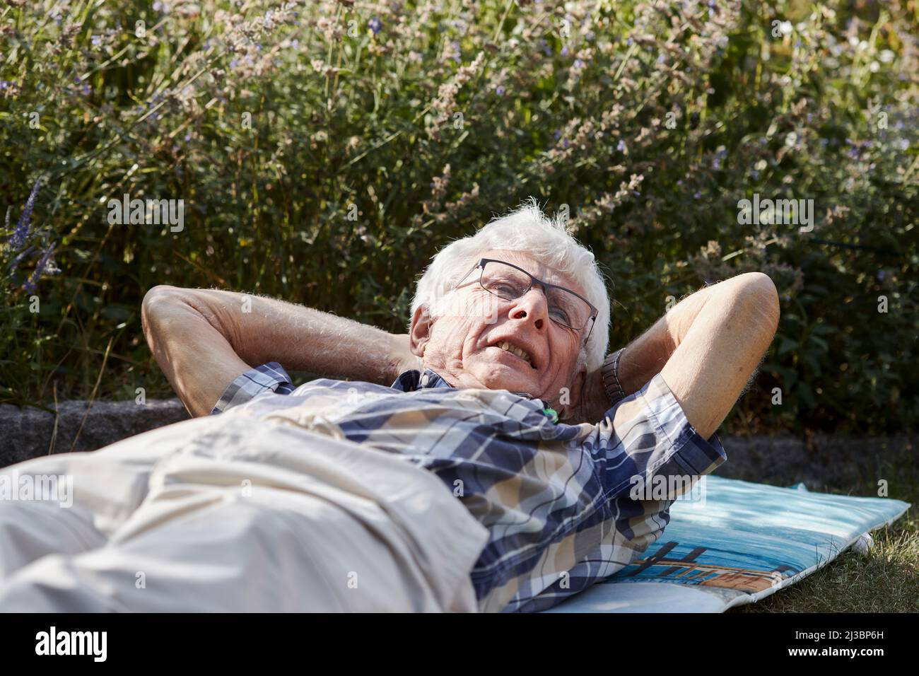 Senior man lying on lawn Stock Photo