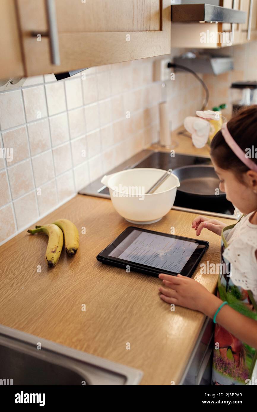 Girl in kitchen using tablet Stock Photo Alamy