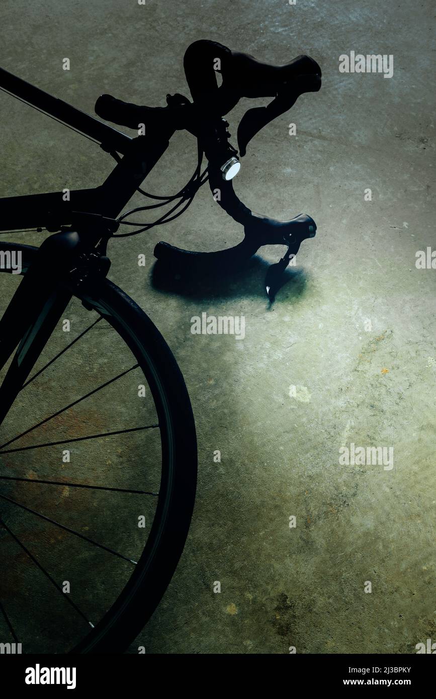 Bicycle with lights on lying on the road. Stock Photo
