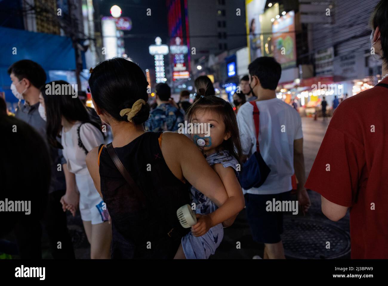 Mother and daughter among group of pedestrians Stock Photo