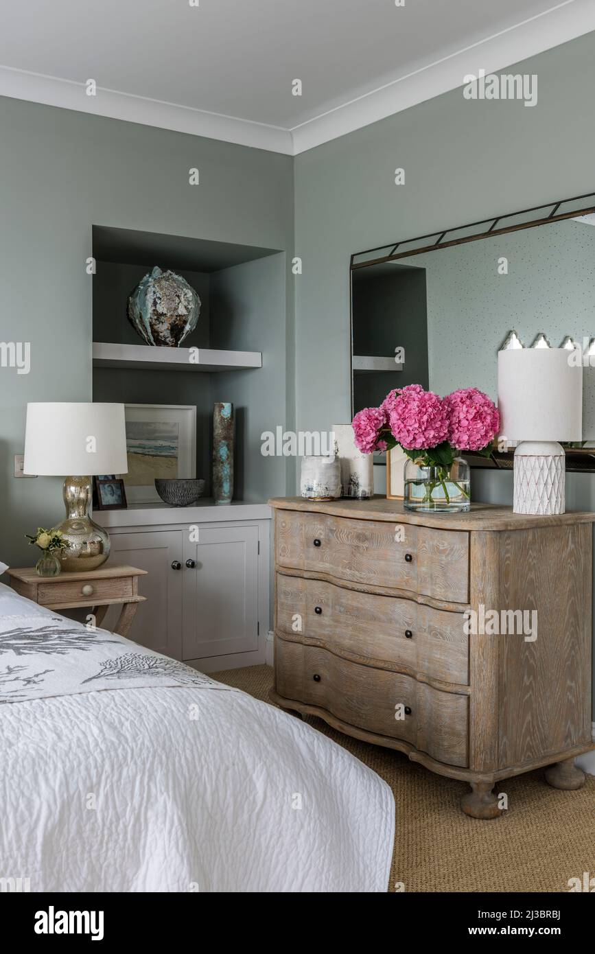 Wooden chest of drawers and mirror with recessed shelves in St Ives bedroom, Cornwall, UK Stock Photo