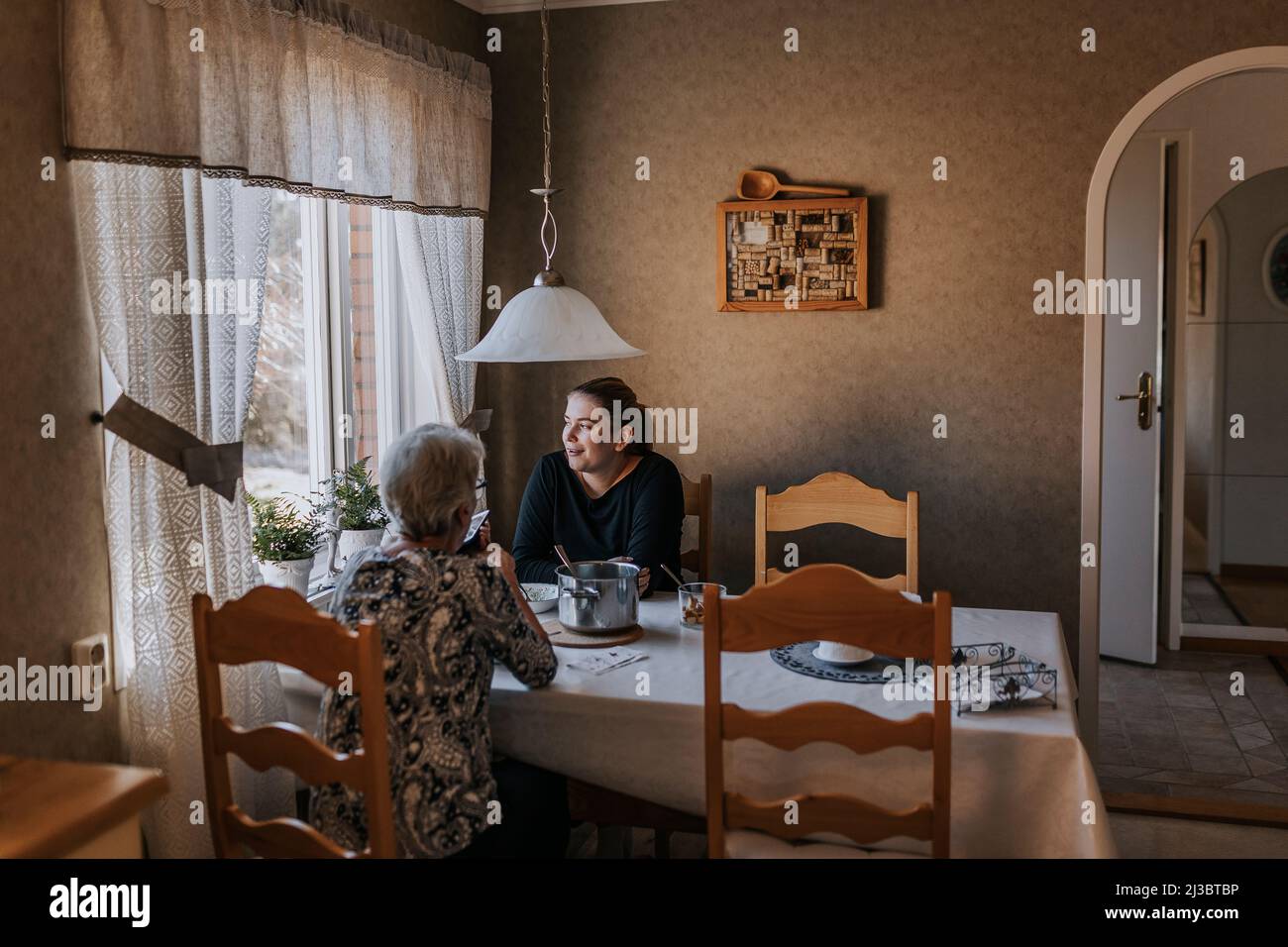Grandmother and adult granddaughter eating at home Stock Photo